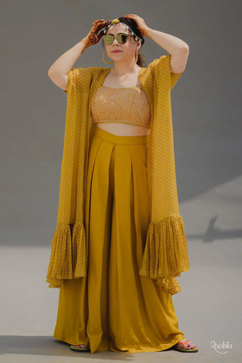 Mustard plain spun silk blouse with abstract embroidery and plain spun silk box pleated pants and bandhej printed organza cape with frills